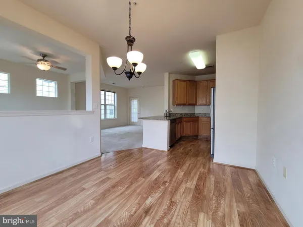 a view of a kitchen with wooden floor and a chandelier