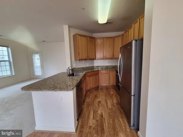 a kitchen with stainless steel appliances granite countertop a refrigerator a sink a stove and island