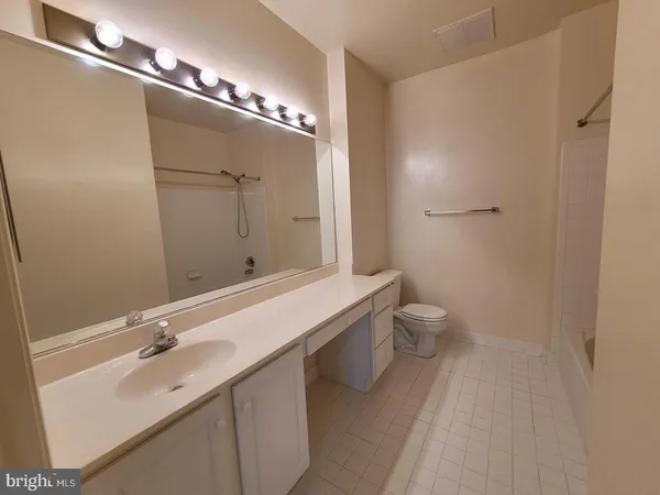 a bathroom with a sink and mirror with toilet