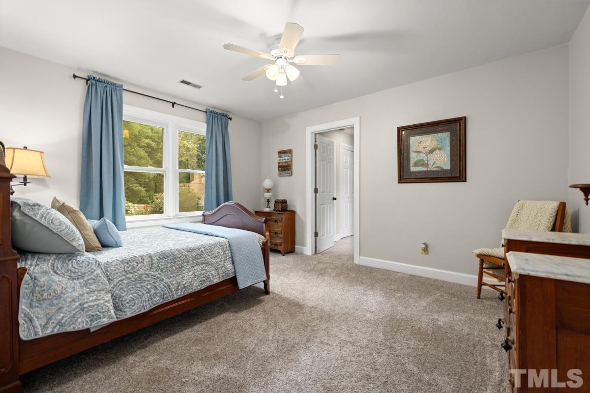 8804 Audley Circle Raleigh, NC 27615 - Photo 29 of 54 a spacious bedroom with a bed and a chandelier