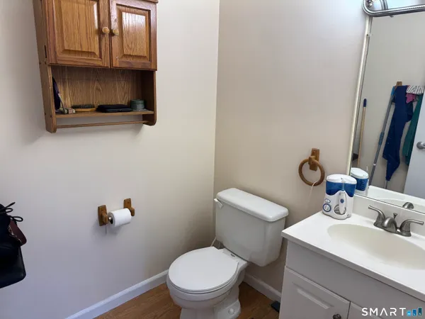 a bathroom with a toilet a sink and mirror