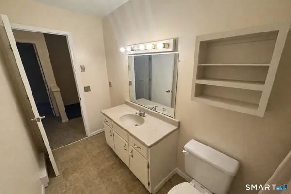 a bathroom with a sink toilet and mirror