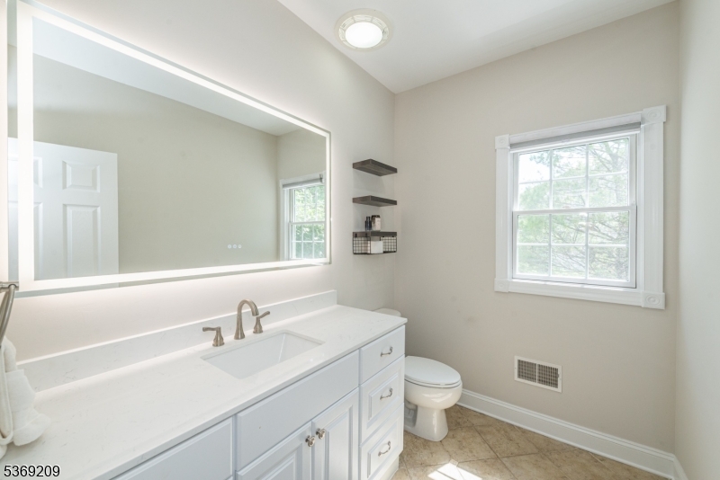 6 Perin Place Succasunna, NJ 07876 - Photo 19 of 39 a bathroom with a granite countertop sink toilet a large mirror and a window