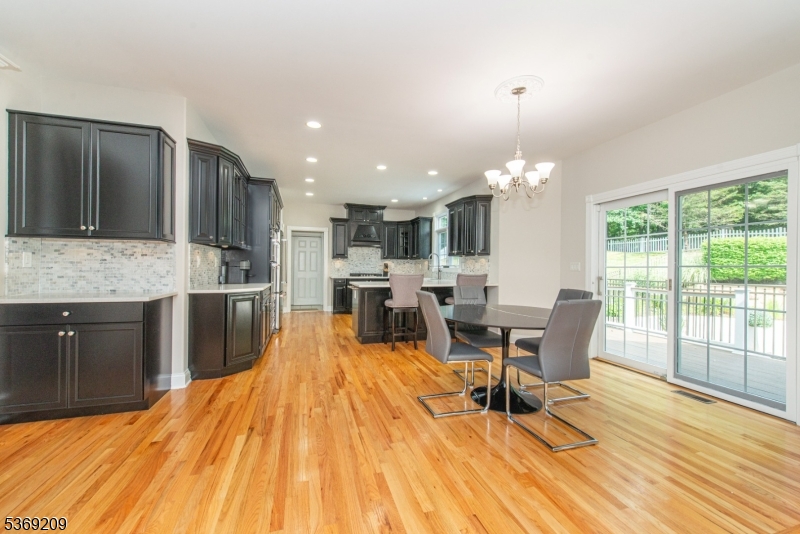 6 Perin Place Succasunna, NJ 07876 - Photo 6 of 39 a kitchen with stainless steel appliances kitchen island granite countertop a sink dishwasher a stove and a dining table with wooden floor
