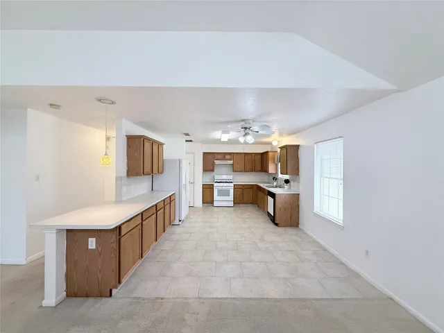 a large white kitchen with a large window