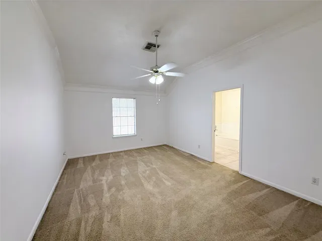 an empty room with a window and a ceiling fan