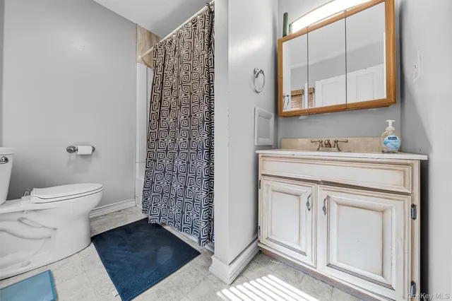 a bedroom with a bed and a large mirror on the dresser