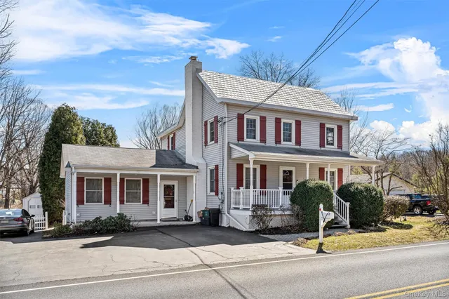 a view of a brick house with many windows next to a road
