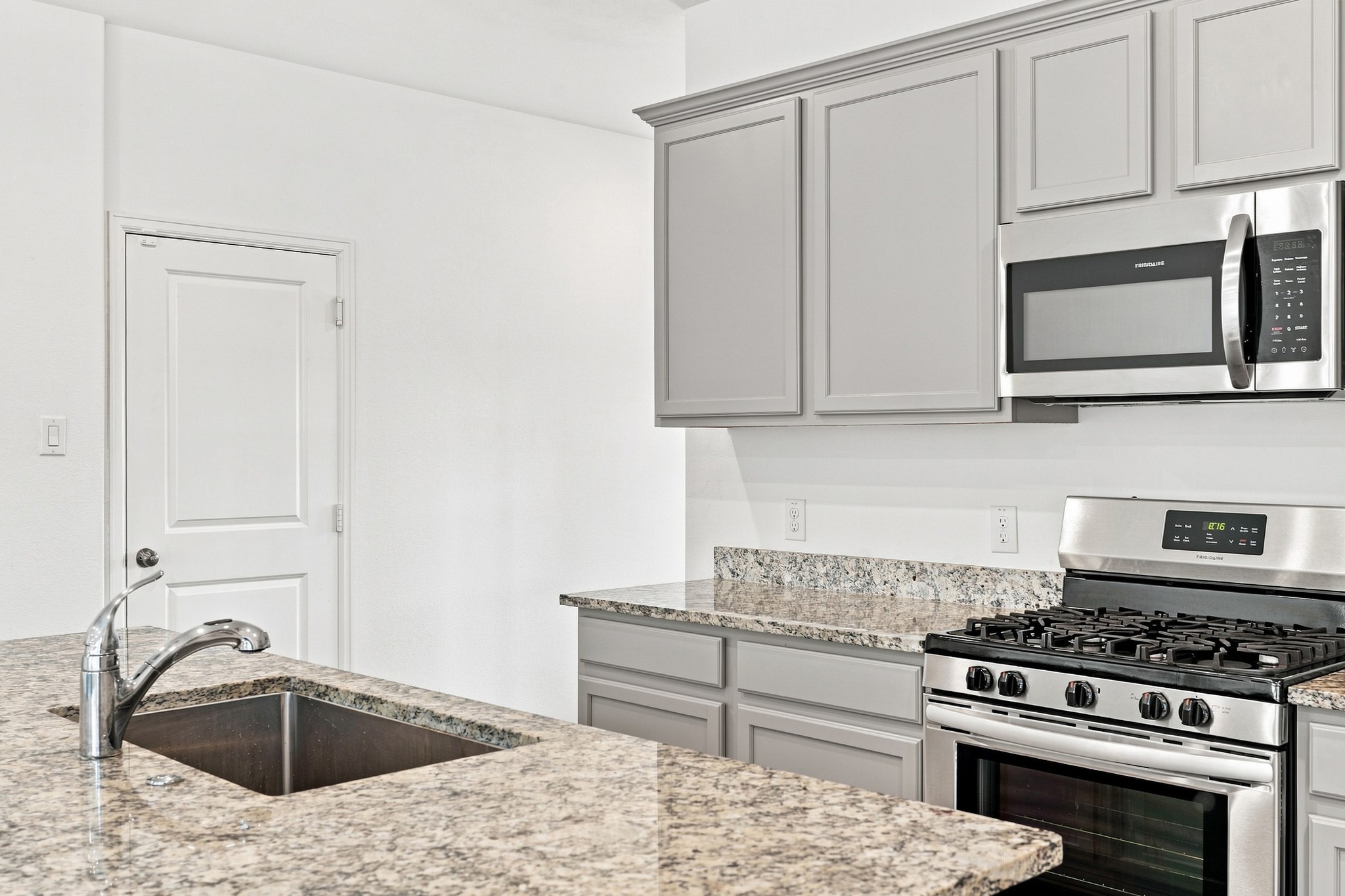 14222 Overbrook Willow Way Rosharon, TX 77583 - Photo 13 of 44 Stylish kitchen with gray cabinetry, granite countertops, stainless steel appliances.