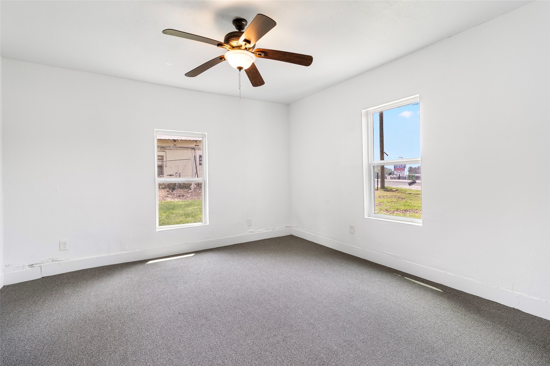 725 South Washington Avenue Livingston, TX 77351 - Photo 15 of 17 an empty room with windows and a ceiling fan