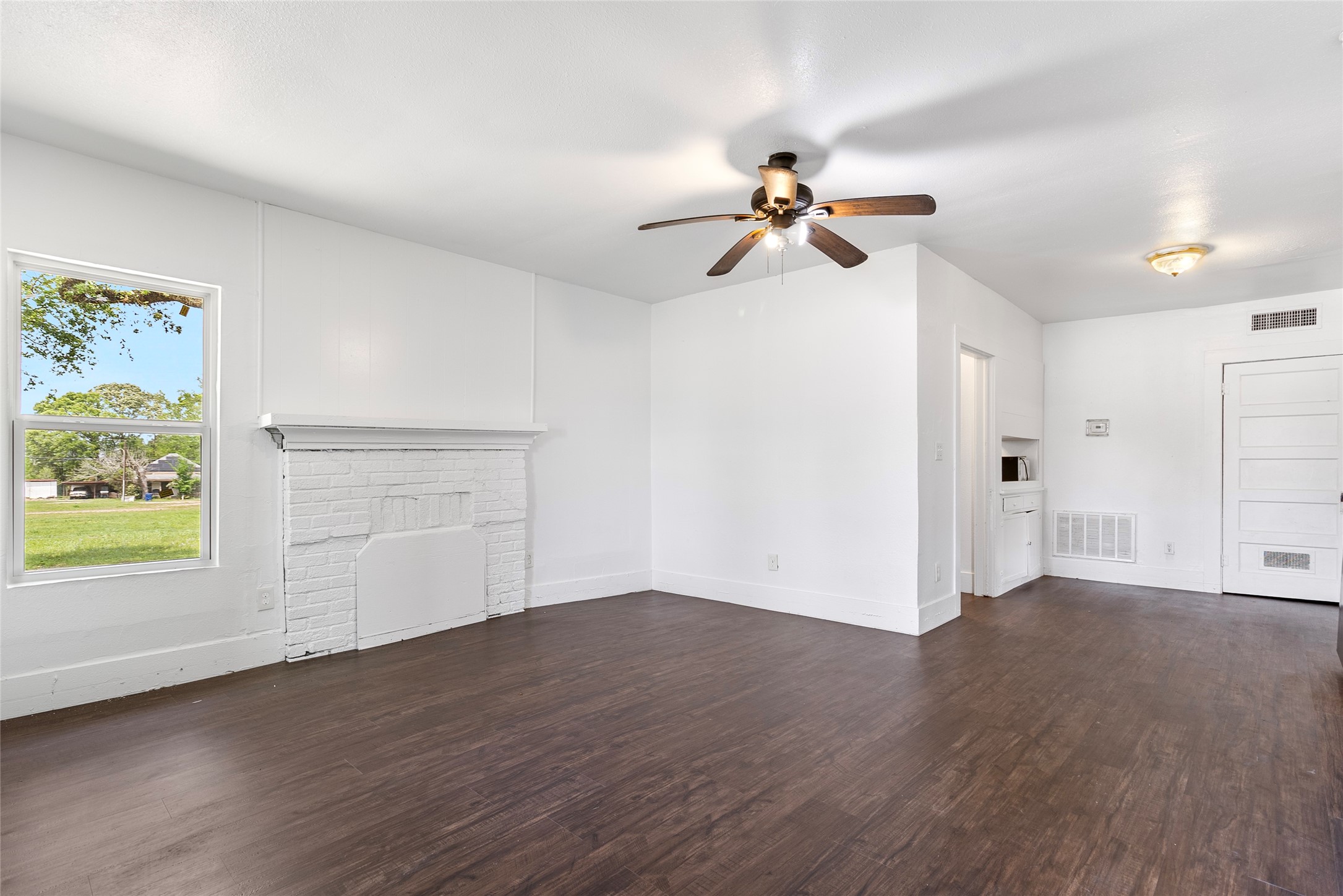 725 South Washington Avenue Livingston, TX 77351 - Photo 2 of 17 a view of empty room with wooden floor and fan