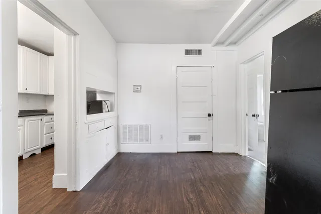 a view of kitchen with white cabinets and wooden floor
