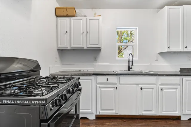 a kitchen with granite countertop a stove and a sink