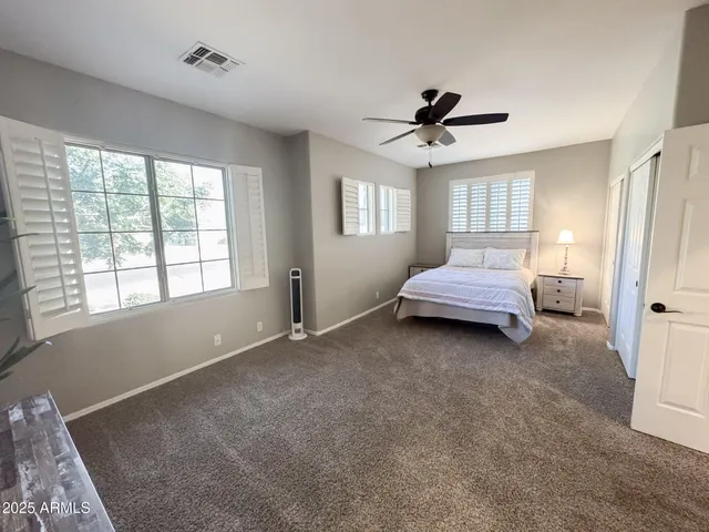 a spacious bedroom with a bed and a window