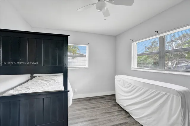 a view of a bedroom with wooden floor