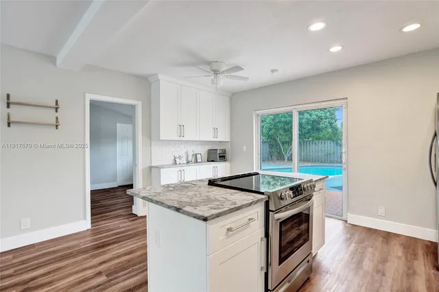 a kitchen that has a sink a stove and a wooden floor