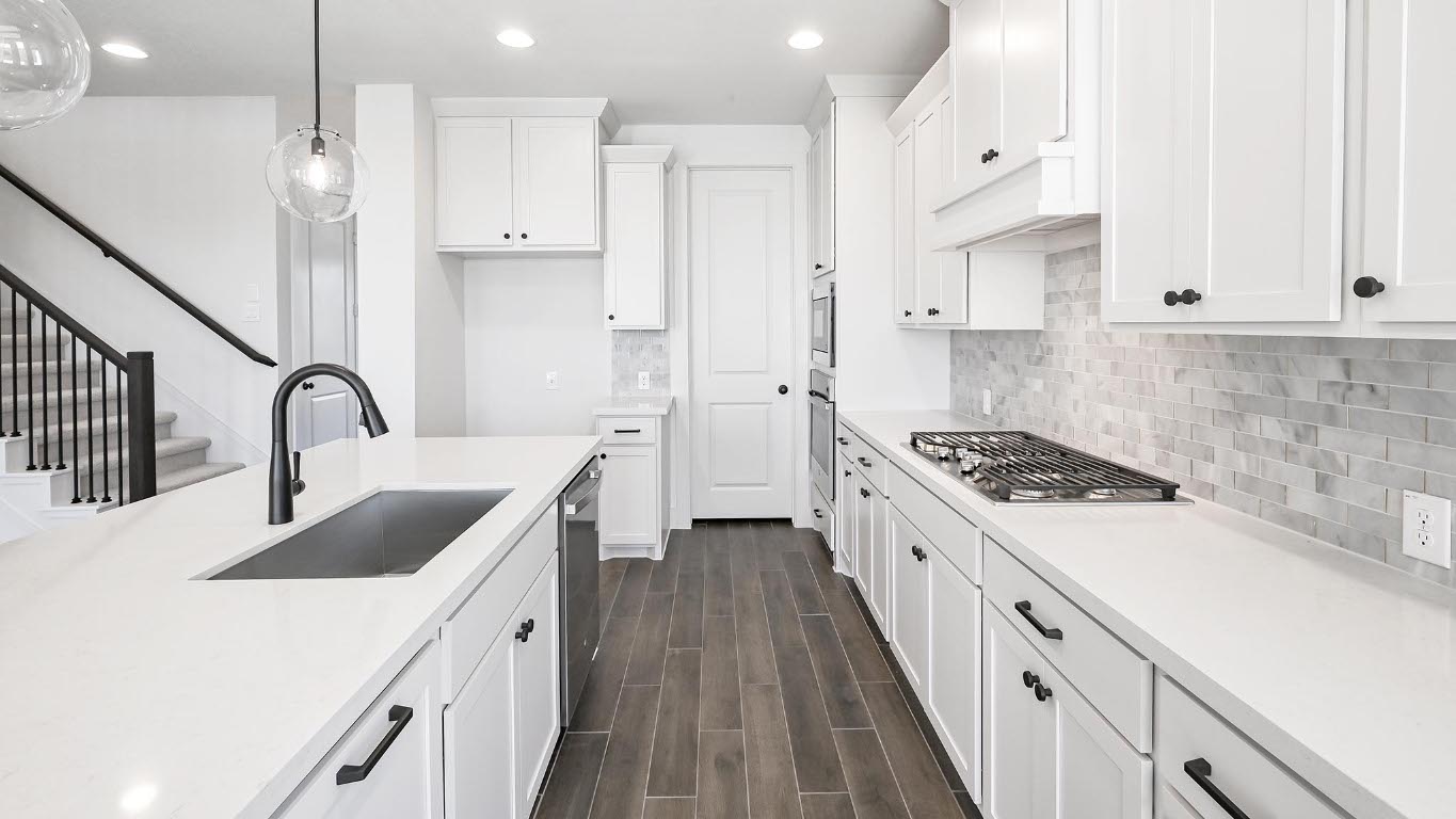 580 Bay Breeze Drive Kyle, TX 78640 - Photo 16 of 35 a kitchen with granite countertop a sink stove and white cabinets
