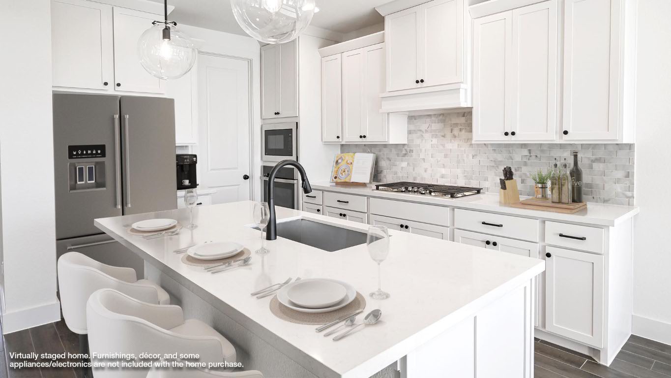 580 Bay Breeze Drive Kyle, TX 78640 - Photo 4 of 35 a kitchen with stainless steel appliances kitchen island granite countertop a sink a stove and white cabinets