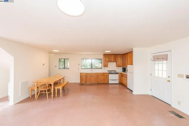 a living room with furniture and a dining table with wooden floor
