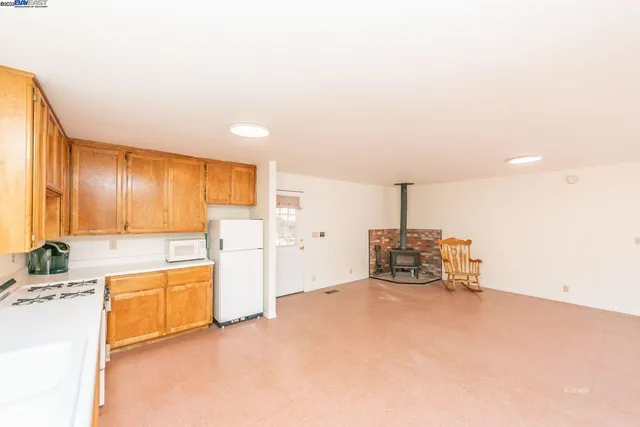 a view of a kitchen with a sink and dishwasher a oven with white cabinets