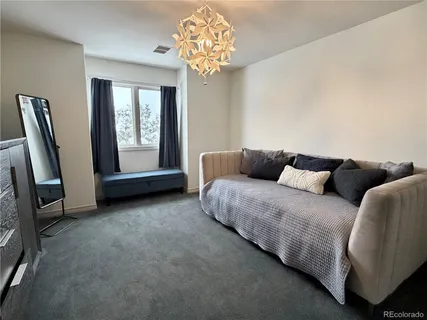 a spacious bedroom with a bed and a chandelier