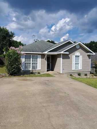 a front view of a house with a garden and yard