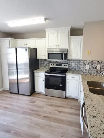 a kitchen with stainless steel appliances a refrigerator sink and cabinets