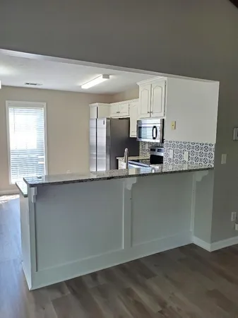 a kitchen with stainless steel appliances granite countertop a stove a sink and a microwave