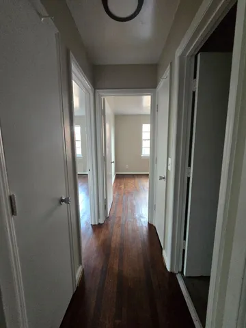 a view of a hallway with wooden floor and front door