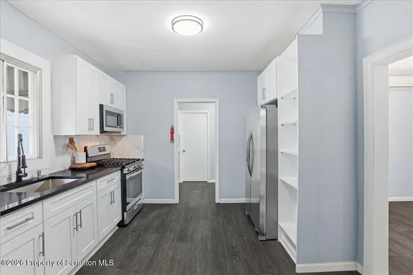 a bathroom with a granite countertop sink a toilet and shower