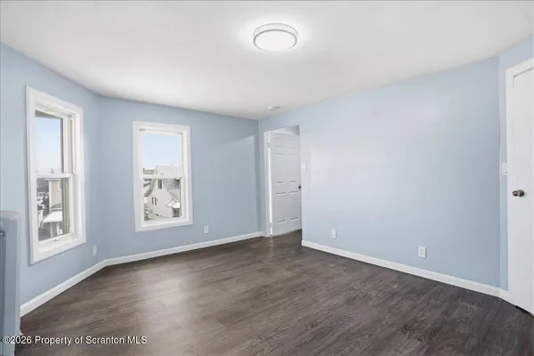 a view of an empty room and wooden floor