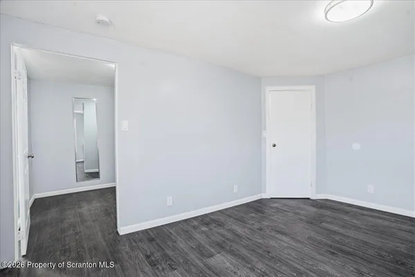 a view of an empty room and wooden floor