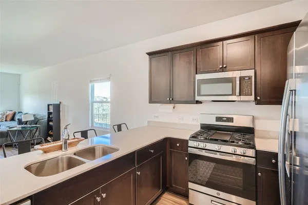 a kitchen with appliances a sink cabinets and a window