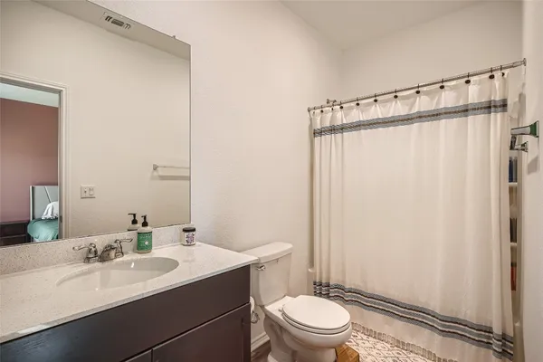 a bathroom with a sink a toilet a mirror and shower