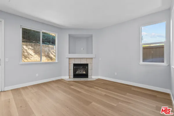 a view of empty room with window and fireplace