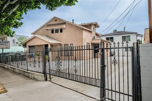 a front view of a house with a iron gate