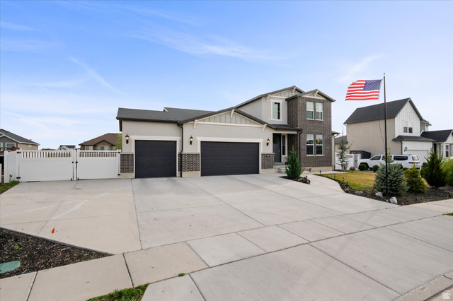3359 Eurasian Crane Road Clinton, UT 84015 - Photo 3 of 71 View of front of house with a gate, a garage, driveway, brick siding, and stucco siding