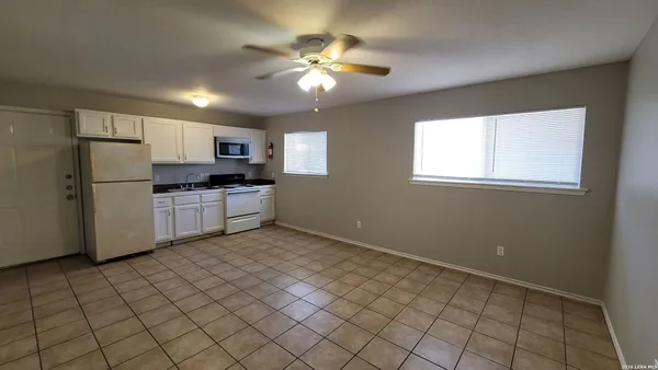 a kitchen with granite countertop a refrigerator and a stove top oven
