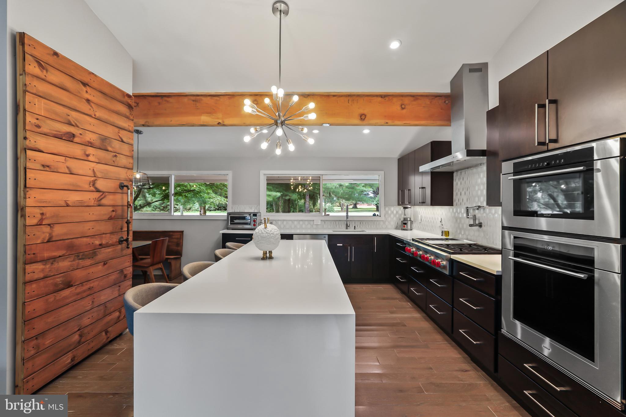 1004 Mercer Road Princeton, NJ 08540 - Photo 10 of 28 a kitchen with stainless steel appliances a large counter top a stove a chimney a sink and a large window