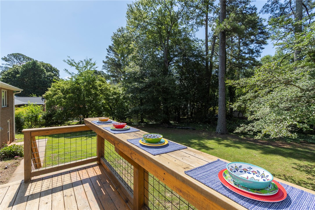207 Laurel Ridge Road Anderson, SC 29621 - Photo 50 of 50 A spacious wooden deck with wire railing provides an ideal spot for outdoor dining amidst natural green surroundings.