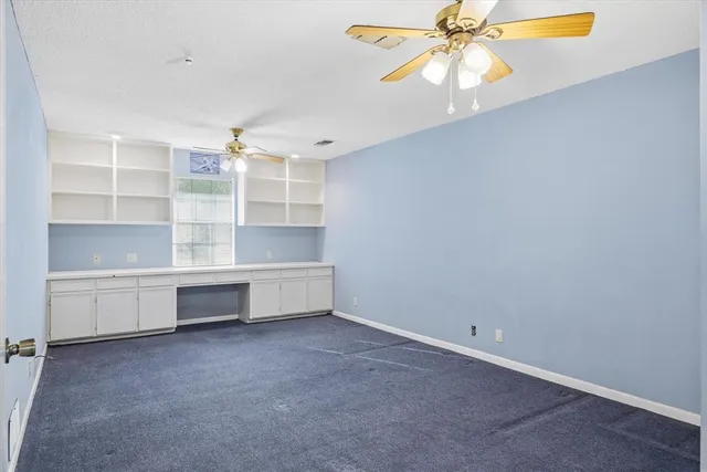 a view of backyard with a table and chairs and wooden fence