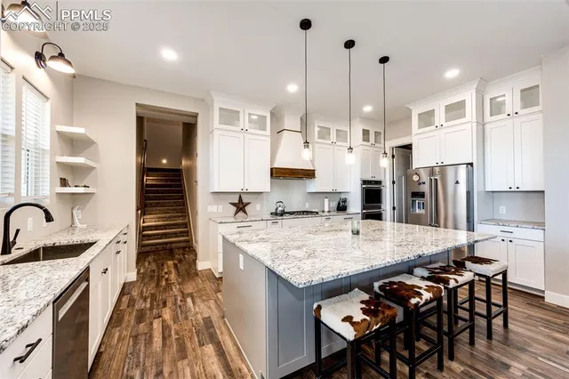 a open kitchen with stainless steel appliances granite countertop a stove refrigerator and a wooden cabinets