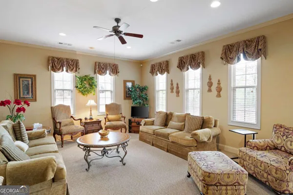 a living room with furniture potted plant and a large window