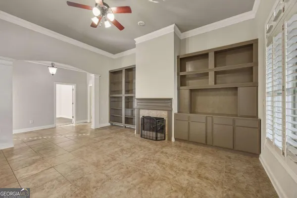 a view of a livingroom with a fireplace cabinet and window