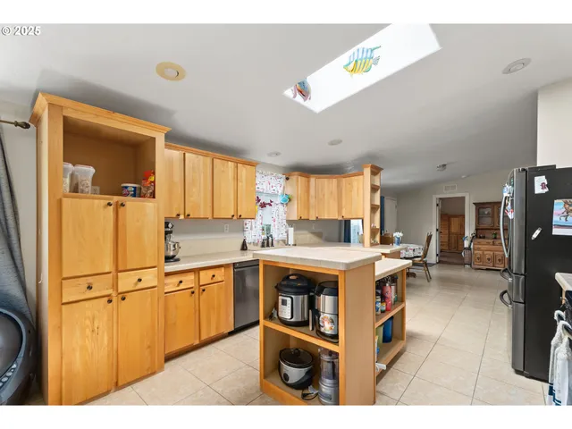 a kitchen with stainless steel appliances granite countertop a refrigerator stove top oven sink and cabinets
