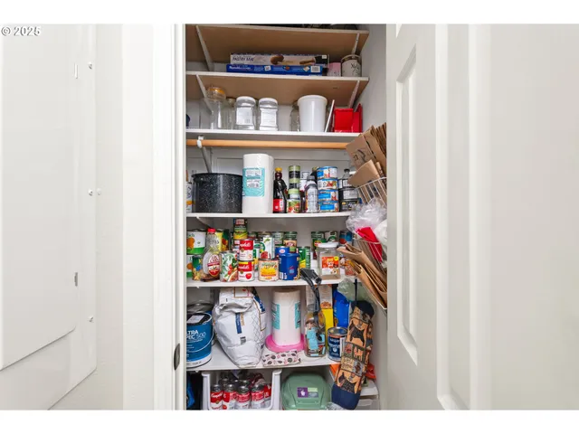 a view of a patio with table and chairs under an umbrella with a small yard