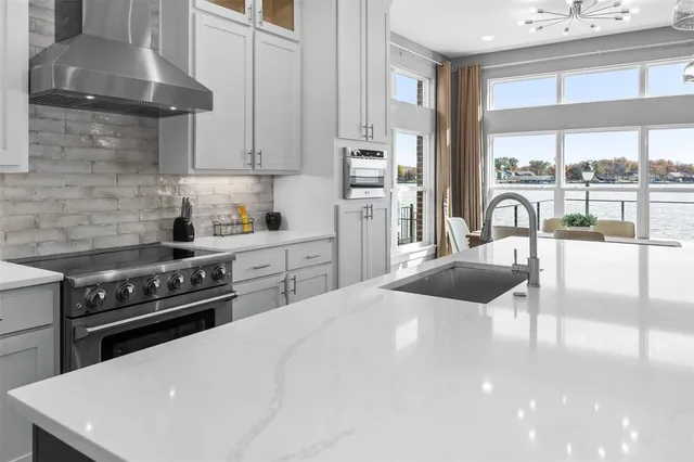 a kitchen with a stove a refrigerator and a sink with wooden floor