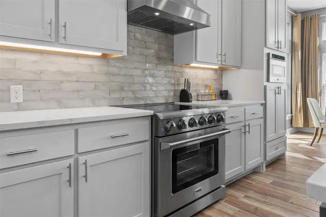 a kitchen with stainless steel appliances white cabinets and a stove