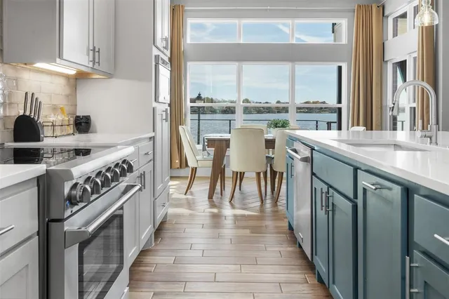 a kitchen with stainless steel appliances granite countertop a stove a sink and a refrigerator