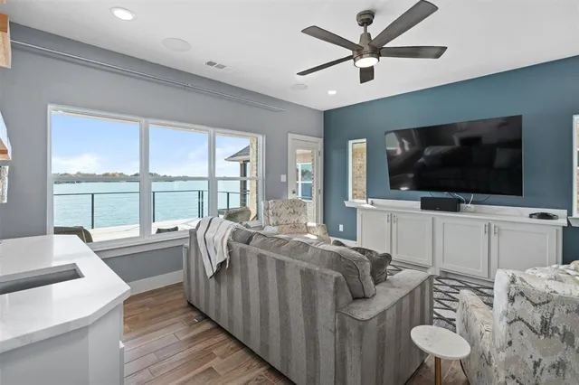 a living room with furniture a flat screen tv and a floor to ceiling window